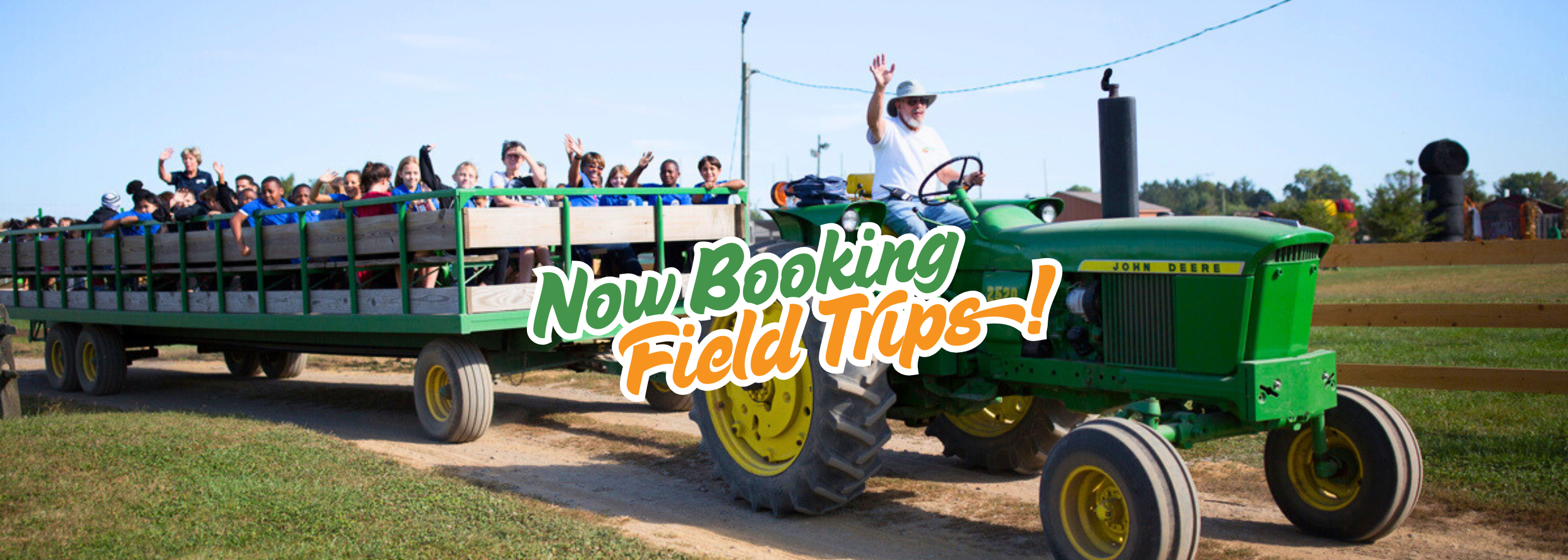 School group on educational spring tour surrounded by blooming trees at Shady Brook Farm.